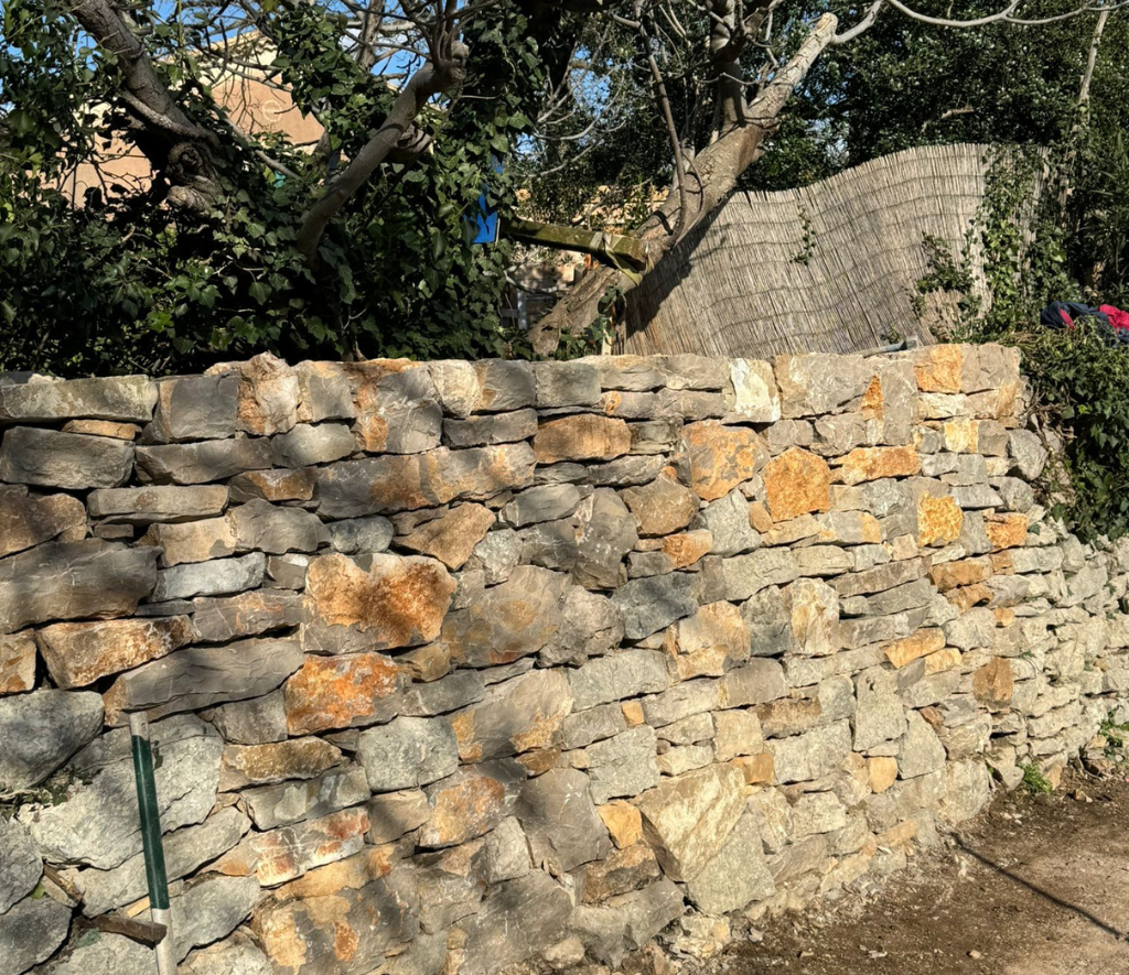 Mur en pierre sèche pour résidence privée réalisé par Aryana Construction, durable et esthétique