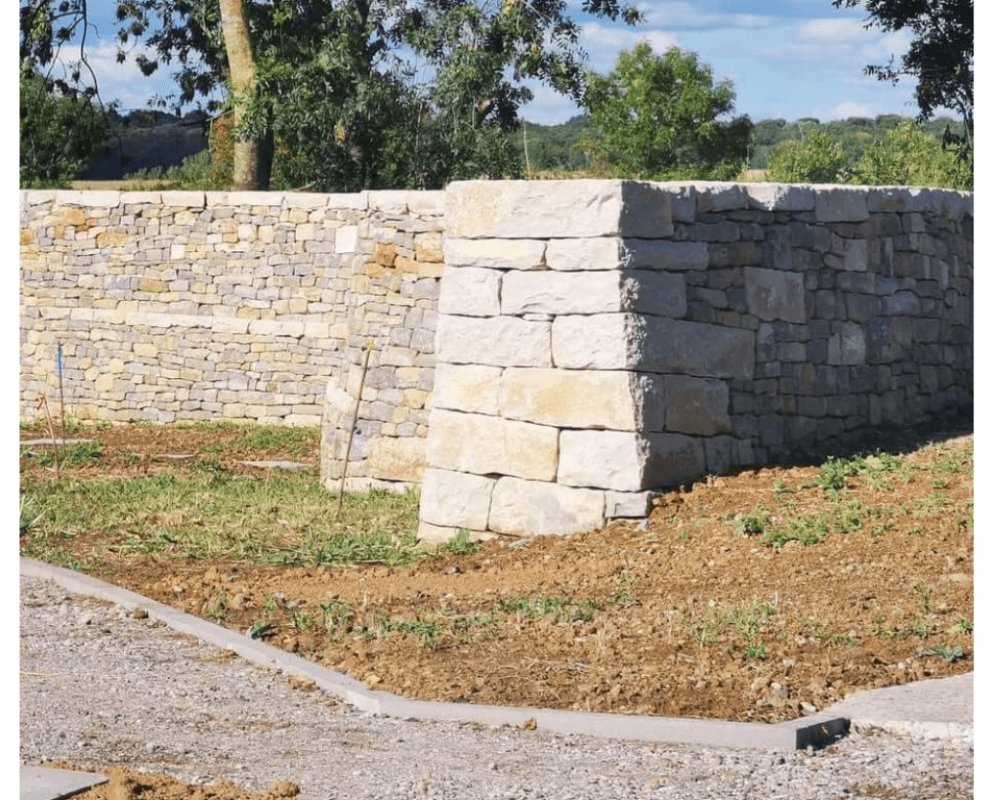 Mur de clôture en pierre sèche délimitant une propriété rurale